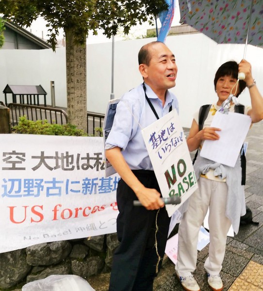 雨の中、街行く人に訴えかけます＝撮影・松中みどり