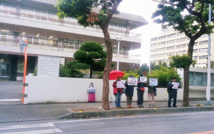 2017年2月9日那覇地裁前で抗議をする人々。後方のピンク色のスーツケースとカバンは筆者のもの=撮影・松中みどり