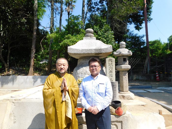 那須与一の墓と伝わる供養塔の前で、（左から）平野雅章住職、那須正美さん＝撮影：ひろよし